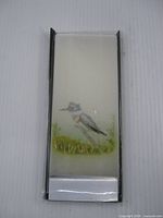 Front view of packaged flat candle showing kingfisher artwork