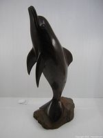 front view of ironwood dolphin sculpture on base