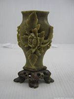 Front view of carved stone vase showing floral relief and base