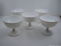 Five identical white milk glass dessert dishes displayed in group view
