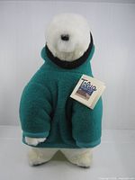 Full view of stuffed polar bear in teal parka