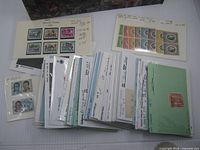 Stack of stock cards, envelopes and sleeves holding multiple Canadian, U.S. and world stamps