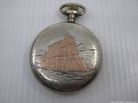 Back of pocket watch showing locomotive engraving and surface wear