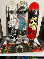Front view of four skateboards and loose trucks