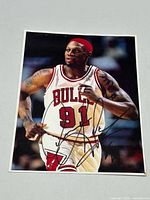 Front view of signed photo showing Dennis Rodman and signature