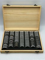 Wooden case open showing rows of encapsulated coins