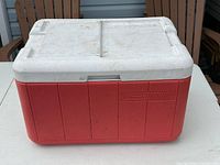 Front view of red and white Coleman chest cooler closed