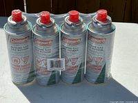 Front view of four Coleman butane cartridges shrink-wrapped