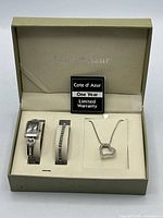 Open gift box showing watch, bracelet, necklace and warranty card