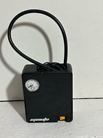 Front view showing compressor body, hose and gauge