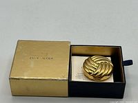 Compact in open box alongside insert