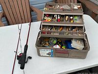 Rod, reel and closed tackle box on table