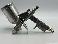 Left side view of paint spray gun with cup attached