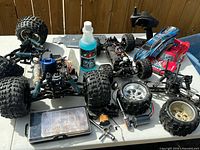 Group view of RC chassis, transmitter, wheels, fuel bottle and parts