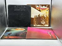 Front covers of AC/DC Back In Black, Led Zeppelin II, AC/DC Let There Be Rock, Queen Greatest Hits