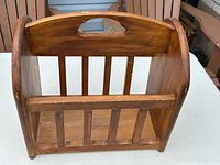 Front view of wooden magazine rack showing handle and slats