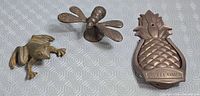 Group shot of pineapple door knocker, bee figurine, frog figurine