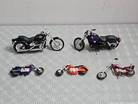 Top-down view of all five diecast motorcycle models