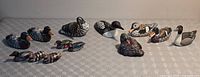 Twelve miniature waterfowl figurines arranged together