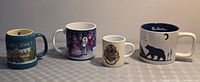 All four mugs lined up showing fronts and relative sizes