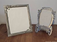 Front view of both pewter picture frames showing designs and relative sizes
