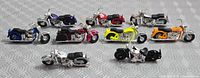 Nine micro diecast motorcycles grouped on patterned surface