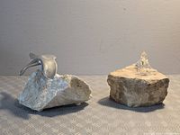 Aluminum stingray and crystal walrus sculptures side by side on stone bases