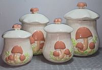 Front view of all four Merry Mushroom canisters showing graduated sizes and design