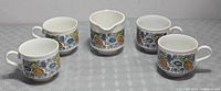 Full set: four teacups and creamer displayed