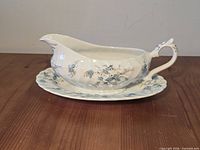 side view of gravy boat on saucer showcasing pattern