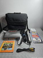 Full lot overview showing console, microphone, cables, carrying case, booklets, memory pack
