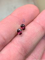 Close-up of both garnet studs showing stone color and setting