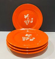 Stack of four orange plates front view