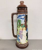 Full view of beer stein front showing relief figures and lid