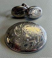 Brooch front and earrings showing etched floral design