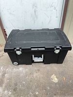 Closed black plastic storage tote front view showing metal latches and handle