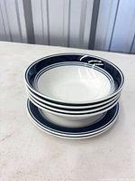 Stacked bowls and plates showing navy blue rim design