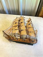 Port-side view of wooden tall ship with cloth sails and rigging