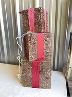 Three stacked glitter gift boxes with power cord visible