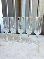 Front view of all five crystal champagne flutes standing side by side