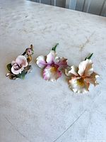 overview of three ceramic flower figurines on tabletop
