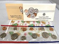 Both boxed envelopes and two sealed coin packs displayed