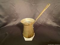 Full view of brass Turkish coffee pot standing upright