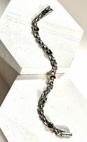 Full view of silver-tone Givenchy bracelet with green crystals
