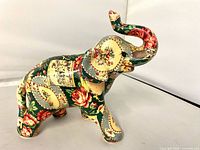 Left side profile of ceramic elephant showing patchwork floral pattern