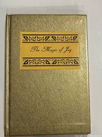Front cover of gold-tone book showing title label