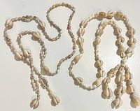 Both shell necklaces coiled side by side showing shell types and tassels
