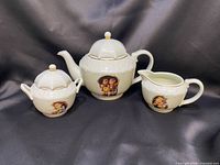 Full view of teapot, sugar bowl, creamer showing design and lids