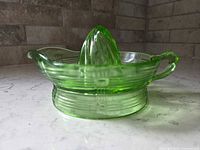 Side view of green uranium glass juicer showing reamer cone, handle and criss-cross pattern