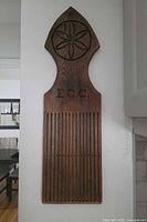 Front view of entire wooden tape loom showing motif, monogram, slats